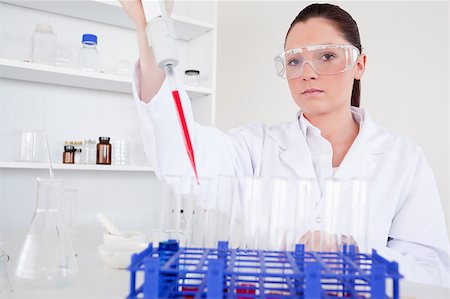 Beautiful female biologist holding a manual pipette with sample from test tubes in a lab Photographie de stock - Aubaine LD & Abonnement, Code: 400-04881572