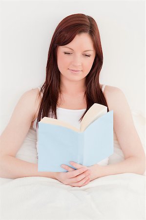 simsearch:400-05894862,k - Beautiful red-haired female reading a book while sitting on her bed Foto de stock - Super Valor sin royalties y Suscripción, Código: 400-04881608