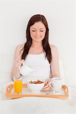 dreaming about eating - Gorgeous red-haired female drinking a glass of orange juice while sitting on her bed Foto de stock - Super Valor sin royalties y Suscripción, Código: 400-04881644