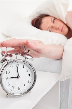 simsearch:400-04881612,k - Pretty red-haired female waking up thanks to an alarm clock in the bedroom Stock Photo - Budget Royalty-Free & Subscription, Code: 400-04881650