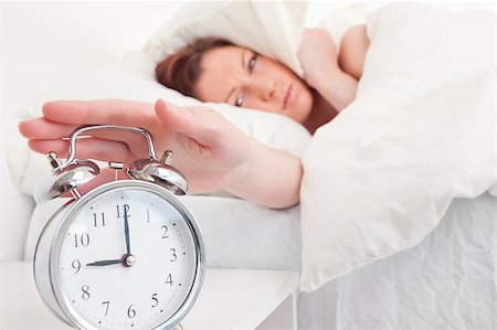 simsearch:400-04881612,k - Gorgeous red-haired female waking up thanks to an alarm clock in the bedroom Stock Photo - Budget Royalty-Free & Subscription, Code: 400-04881651