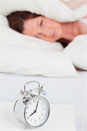 simsearch:400-04881612,k - Beautiful red-haired woman waking up thanks to an alarm clock in the bedroom Stock Photo - Budget Royalty-Free & Subscription, Code: 400-04881652
