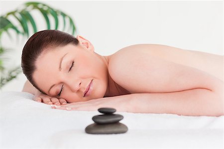 simsearch:400-04881818,k - Red-haired woman lying on her belly in a spa with massage stone next to her Fotografie stock - Microstock e Abbonamento, Codice: 400-04881852