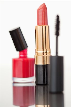 A mascara tube with a pale red lipstick and a nail polish flask against a white background Stock Photo - Budget Royalty-Free & Subscription, Code: 400-04882291