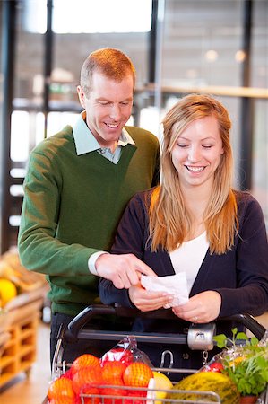 A happy couple looking at a grocery list in a supermarket Stock Photo - Budget Royalty-Free & Subscription, Code: 400-04882421