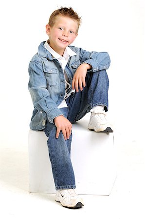 young attractive boy wearing a blue jean jacket sitting and smiling Stockbilder - Microstock & Abonnement, Bildnummer: 400-04883232