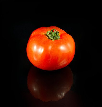 Ripe tomato with a reflection isolated on a black background Fotografie stock - Microstock e Abbonamento, Codice: 400-04883338