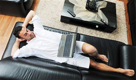 Portrait of a relaxed young guy using laptop at home indoor Foto de stock - Super Valor sin royalties y Suscripción, Código: 400-04883547
