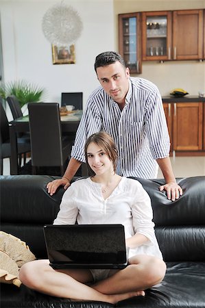 joyful couple relax and work on laptop computer at modern livingroom indoor home Stock Photo - Budget Royalty-Free & Subscription, Code: 400-04883551