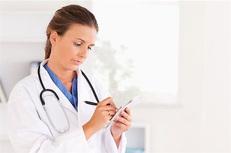 simsearch:400-05192324,k - Concentrated doctor writing something down in the surgery Stock Photo - Budget Royalty-Free & Subscription, Code: 400-04894205
