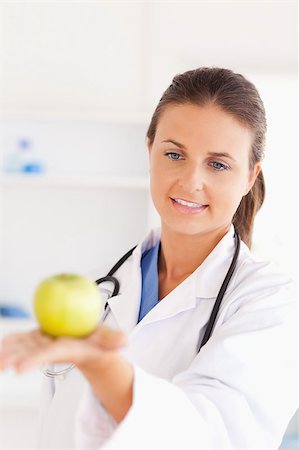 simsearch:400-05728490,k - Smiling doctor with stethoscope looking at an apple in the surgery Photographie de stock - Aubaine LD & Abonnement, Code: 400-04894210