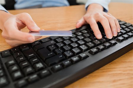 Woman typing on keyboard holding a credit card in her office Stock Photo - Budget Royalty-Free & Subscription, Code: 400-04894315