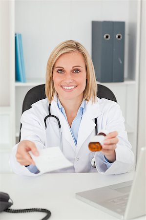 simsearch:400-04417775,k - Charming blonde doctor holding prescription and medicine smiles into camera in her office Foto de stock - Super Valor sin royalties y Suscripción, Código: 400-04894361