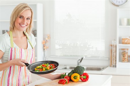 simsearch:400-04139196,k - Woman showing cutted peppers in pan in the kitchen Foto de stock - Royalty-Free Super Valor e Assinatura, Número: 400-04894377