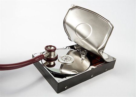 The hard disk is opened by brute force and a stethoscope is listening for data. Neutral grey background Photographie de stock - Aubaine LD & Abonnement, Code: 400-04894585