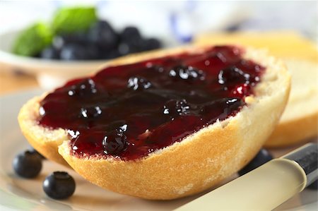 Blueberry jam on half a bun with a knife beside (Selective Focus, Focus on the front of the bun and jam) Stock Photo - Budget Royalty-Free & Subscription, Code: 400-04894613