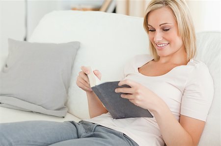 simsearch:400-04905604,k - Smiling woman reading a book in her living room Stockbilder - Microstock & Abonnement, Bildnummer: 400-04894971