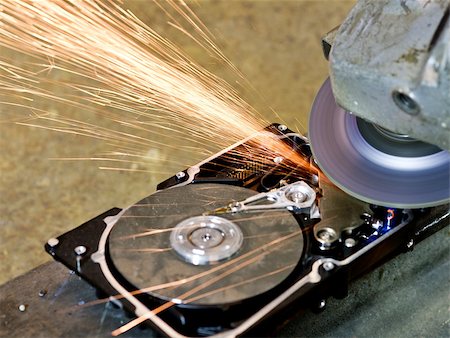 grinder working on open hard drive. Many sparks are flying away. rusty background Stock Photo - Budget Royalty-Free & Subscription, Code: 400-04894986