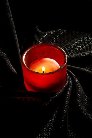 candle on a red glass holder over a black fabric background Photographie de stock - Aubaine LD & Abonnement, Code: 400-04895418