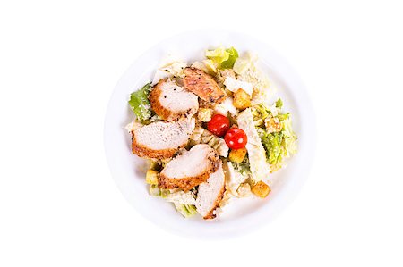 salada caesar - Caesar salad with chicken on a plate. On a white background. Foto de stock - Royalty-Free Super Valor e Assinatura, Número: 400-04896024