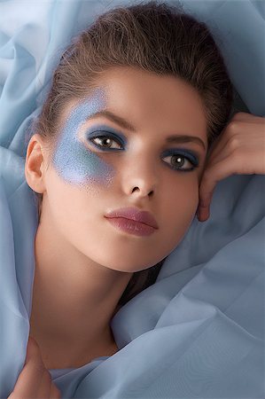 simsearch:400-04420197,k - face shot of a pretty young woman with azure glitter make up and laying on fabric pieces Foto de stock - Super Valor sin royalties y Suscripción, Código: 400-04896287