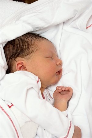 A young baby is sleeping on a white bed with a blanket. Stock Photo - Budget Royalty-Free & Subscription, Code: 400-04898216