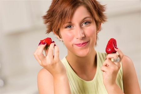 feverpitched (artist) - Pretty Red Haired Woman Eating Strawberry in Her Kitchen. Foto de stock - Royalty-Free Super Valor e Assinatura, Número: 400-04899189