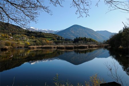 simsearch:400-04761029,k - Distant peaks reflecting in the still waters of a lake during a sunny Autumn day Fotografie stock - Microstock e Abbonamento, Codice: 400-04899897