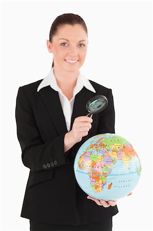 Attractive female in suit holding a globe and using a magnifying glass while standing against a white background Stock Photo - Budget Royalty-Free & Subscription, Code: 400-04890633