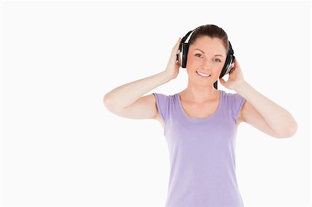 simsearch:400-06690896,k - Charming woman posing with headphones while standing against a white background Stock Photo - Budget Royalty-Free & Subscription, Code: 400-04890809