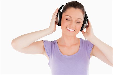 simsearch:400-06690896,k - Lovely woman posing with headphones while standing against a white background Stock Photo - Budget Royalty-Free & Subscription, Code: 400-04890814