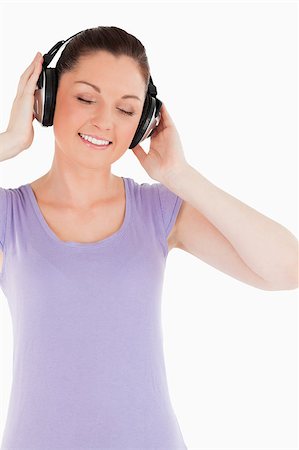 simsearch:400-06690896,k - Good looking female posing with headphones while standing against a white background Stock Photo - Budget Royalty-Free & Subscription, Code: 400-04890816