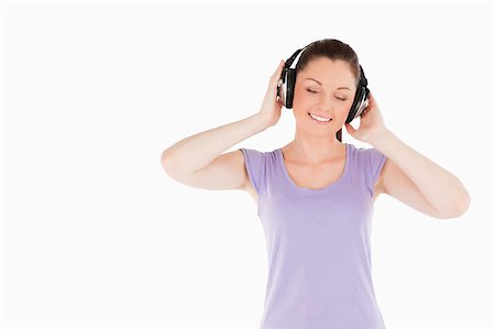 simsearch:400-06690896,k - Pretty woman posing with headphones while standing against a white background Stock Photo - Budget Royalty-Free & Subscription, Code: 400-04890812