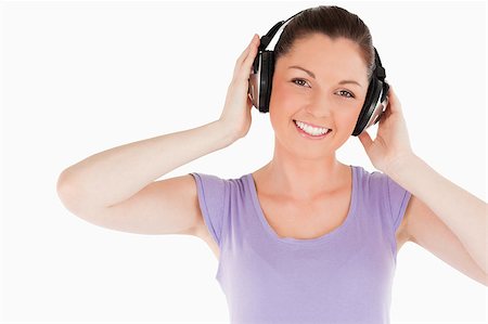 simsearch:400-06690896,k - Cute woman posing with headphones while standing against a white background Stock Photo - Budget Royalty-Free & Subscription, Code: 400-04890813