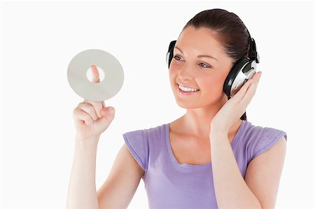 simsearch:400-06690896,k - Good looking female with headphones holding a CD while standing against a white background Stock Photo - Budget Royalty-Free & Subscription, Code: 400-04890838