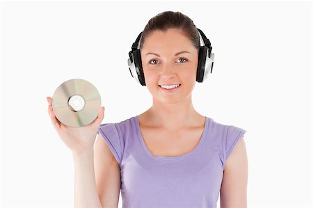 simsearch:400-06690896,k - Good looking woman with headphones holding a CD while standing against a white background Stock Photo - Budget Royalty-Free & Subscription, Code: 400-04890832