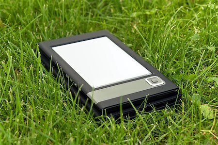 simsearch:400-08501429,k - Portable electronic book lying on the grass. Photographie de stock - Aubaine LD & Abonnement, Code: 400-04892098