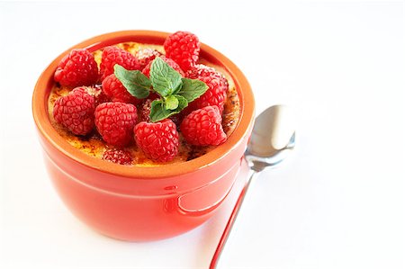 French creme brulee dessert with raspberries and mint covered with caramelized sugar in red terracotta ramekin on white background Stock Photo - Budget Royalty-Free & Subscription, Code: 400-04892432