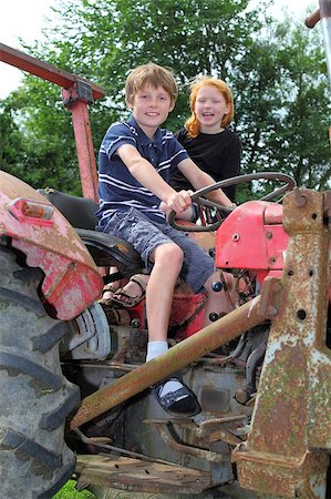 Two children playing on an old tractor Stock Photo - Budget Royalty-Free & Subscription, Code: 400-04892973