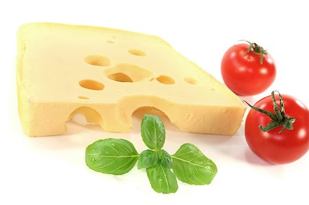 emmentaler cheese - a piece of Swiss cheese with tomato and basil on a white background Stock Photo - Budget Royalty-Free & Subscription, Code: 400-04893378