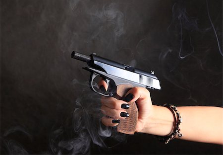 simsearch:400-07209318,k - Black pistol in female hand on a background of a smoke Stockbilder - Microstock & Abonnement, Bildnummer: 400-04893422