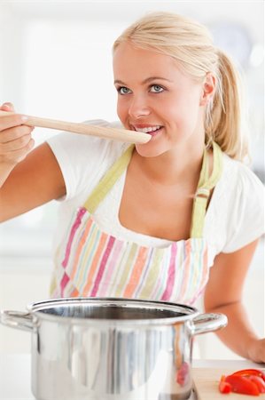 Portrait of a blonde woman tasting her meal while looking away from the camera Stock Photo - Budget Royalty-Free & Subscription, Code: 400-04904433