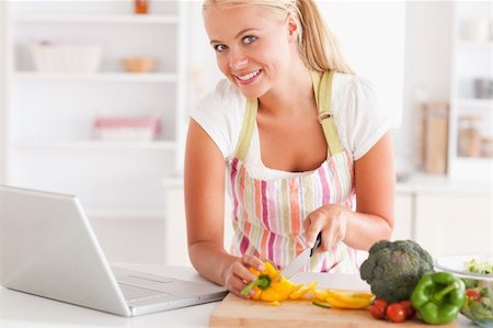 simsearch:400-05748090,k - Close up of a blonde woman using a laptop to cook in her kitchen Foto de stock - Super Valor sin royalties y Suscripción, Código: 400-04904452