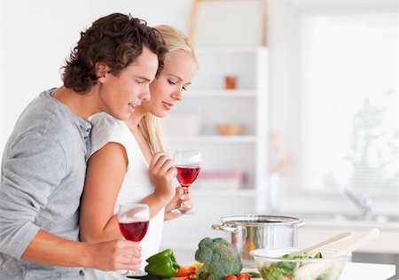 Couple cooking while having a glass of wine in their kitchen Stock Photo - Budget Royalty-Free & Subscription, Code: 400-04904484