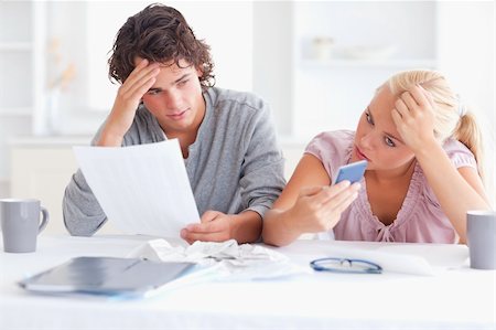 Unhappy couple doing accounts in their living room Stock Photo - Budget Royalty-Free & Subscription, Code: 400-04904659