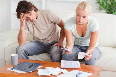 Stressed couple calculating their expenses in the living room Stock Photo - Budget Royalty-Free & Subscription, Code: 400-04904918