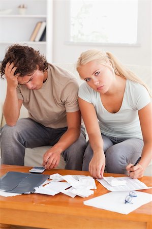 simsearch:400-05746763,k - Despaired worn out couple calculating their expenses in the living room Stock Photo - Budget Royalty-Free & Subscription, Code: 400-04904932