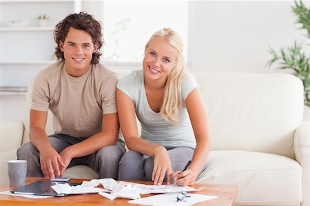 Cute couple smiling into the camera in the living room Stock Photo - Budget Royalty-Free & Subscription, Code: 400-04904933