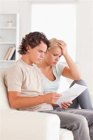 Unhappy couple reading letters in the living room Stock Photo - Budget Royalty-Free & Subscription, Code: 400-04904954