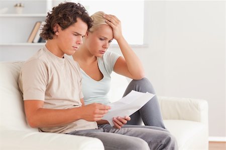 Unhappy couple holding an invoice in the living room Stock Photo - Budget Royalty-Free & Subscription, Code: 400-04904956